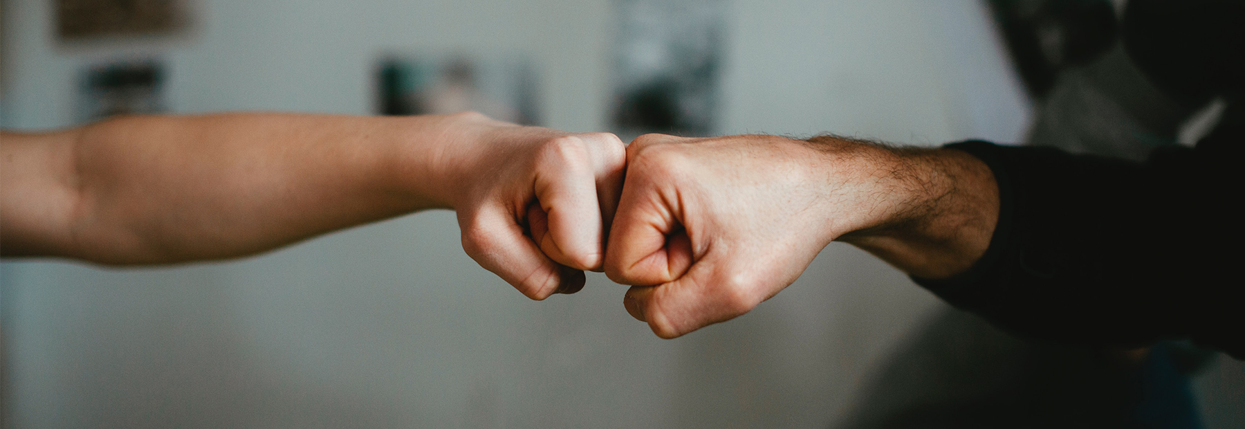 Two colleagues bumping fists in an endearing manner.