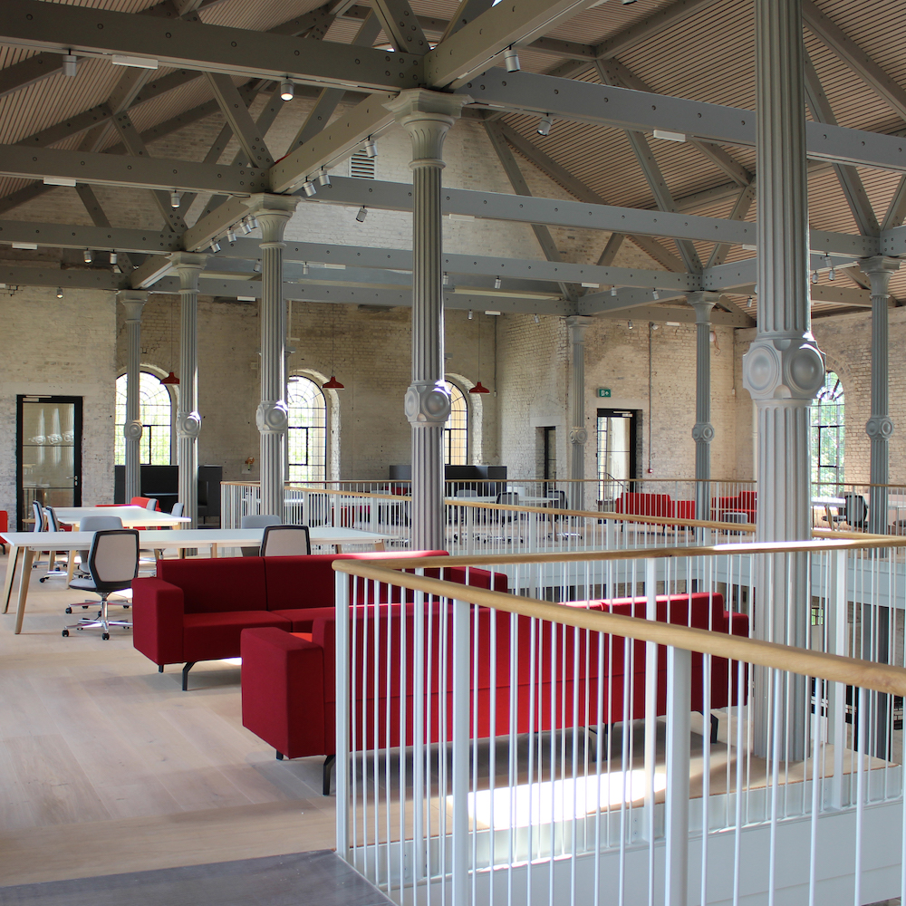 An internal picture of the coworking space. Tables and break out areas spread out over the first floor of the Dockyard Church in Sheerness